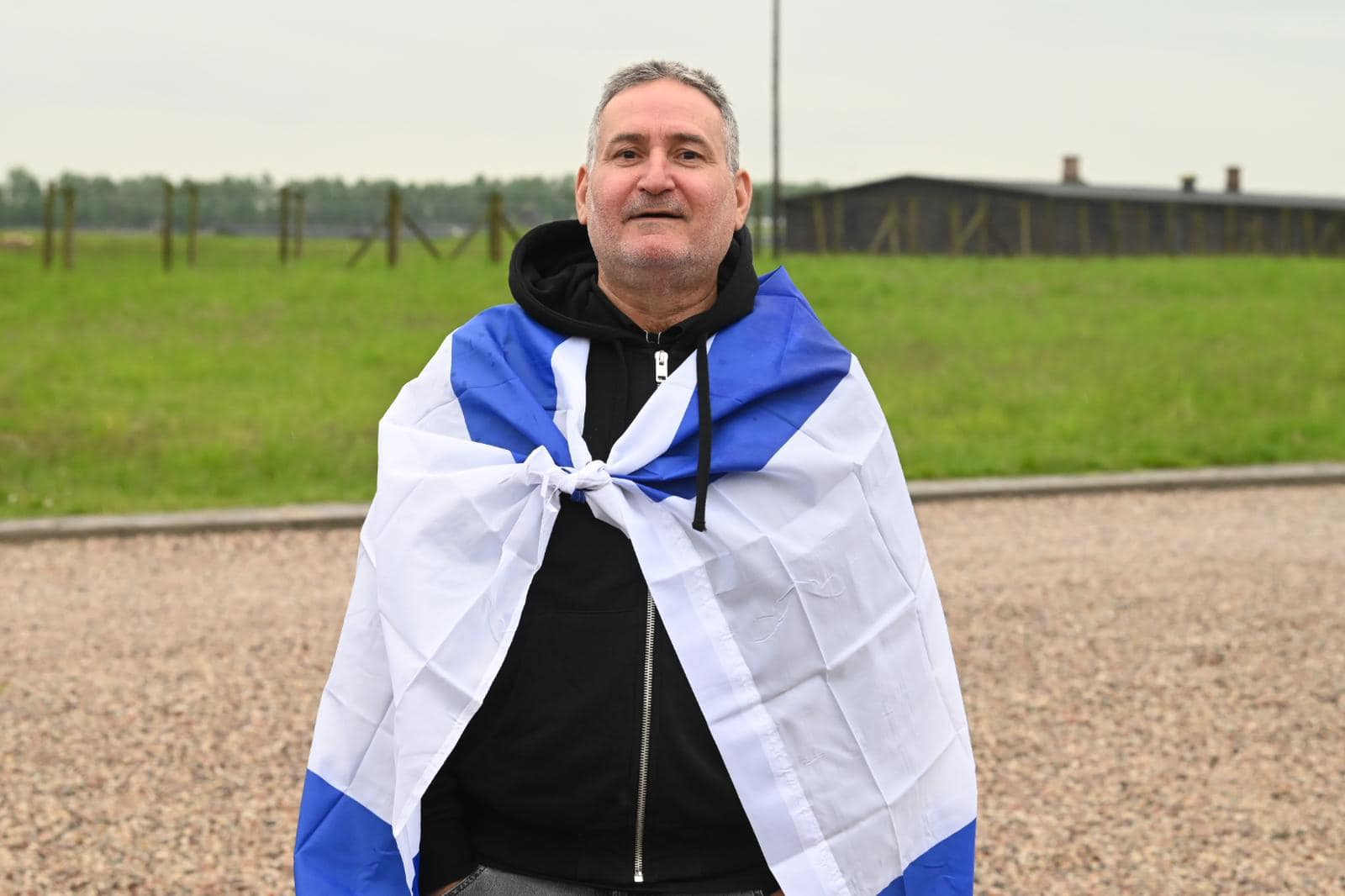 משתתף בסיור פולין עטוף בדגל ישראל משתתף בסיור פולין עטוף בדגל ישראל